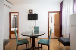a room with a table and chairs and a bedroom at Apartment Majer in Medulin