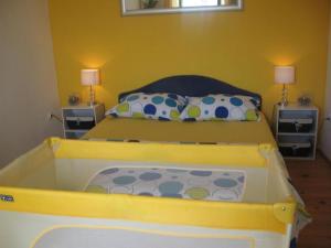 ein Schlafzimmer mit einem gelben Bett und einer großen Badewanne in der Unterkunft Apartment Luca in Prvić Luka