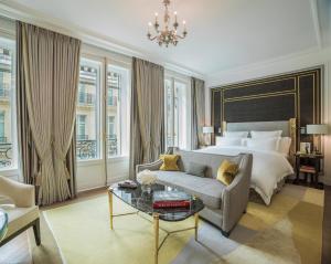 ein Schlafzimmer mit einem Bett, einem Sofa und einem Tisch in der Unterkunft Hotel de Crillon in Paris