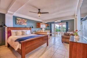 a bedroom with a bed and a living room at Tropical Suites Hotel in Bocas Town