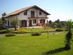 a house with a green yard in front of it at Aurora dell'Etna in Zafferana Etnea