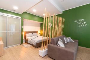Dormitorio verde con cama y sofá en Enjoy Room- Appartamento con parcheggio GRATUITO e COLAZIONE DELIZIOSA !, en Turín