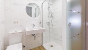een witte badkamer met een wastafel en een douche bij Pensión 9 de Abril in O Pedrouzo