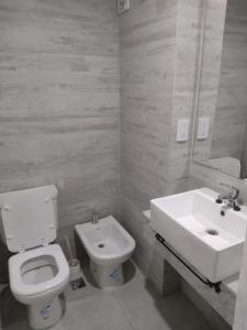 Un baño blanco con inodoro y lavabo. en Al Mar - Torres del Este, en Monte Hermoso