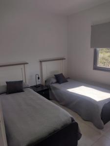 dos camas sentadas una al lado de la otra en un dormitorio en Al Mar - Torres del Este en Monte Hermoso