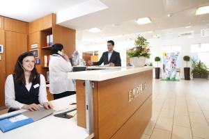 a woman sitting at a counter in a dental office at Gästehaus Pauline in Berlin