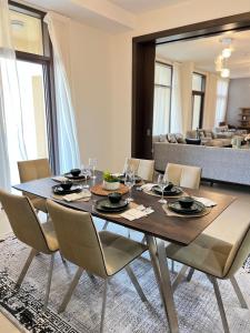 W muscat bay في مسقط: غرفة طعام مع طاولة وكراسي خشبية