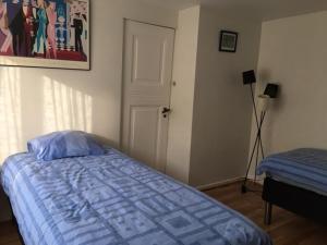 Schlafzimmer mit einem Bett mit blauer Decke in der Unterkunft Motel Villa Søndervang twin room in Harndrup