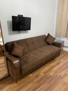 倫敦的住宿－007- S1premium location studio apartment central London，客厅设有棕色沙发,配有平面电视