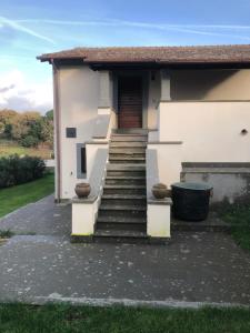 een wit huis met een trap naar een deur bij Il Rifugio del Vescovo in Vetralla
