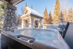 a hot tub with a gazebo in the snow at Lagoons by Outpost Whistler in Whistler