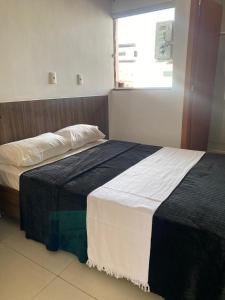 a bedroom with two beds and a window at HOTEL E POUSADA VILLA D' MARI in Goiânia