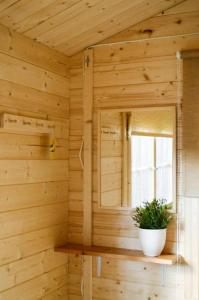 a wooden room with a window and a plant on a shelf at Karjamaa Garden Bungalows in Pärnu