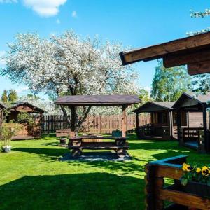 a picnic table and a gazebo in a yard at Karjamaa Garden Bungalows in Pärnu