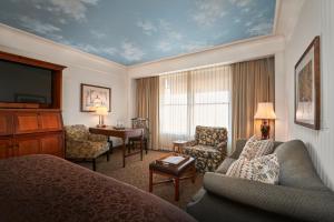 a hotel room with a bed and a living room at O.Henry Hotel in Greensboro