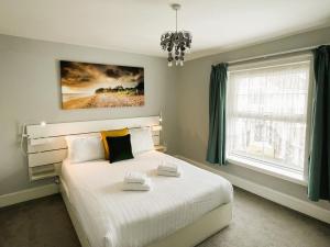 Un dormitorio con una gran cama blanca y una ventana en Kema Cottage, en East Cowes