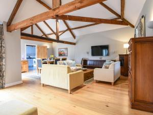 ein Wohnzimmer mit Holzdecken sowie einem Tisch und Stühlen in der Unterkunft Ware Barn Cottage in Lyme Regis
