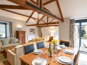 a dining room with a wooden table and chairs at Ware Barn Cottage in Lyme Regis