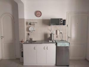 una cocina con armarios blancos y un reloj en la pared en Monoambiente en excelente ubicación en Mendoza