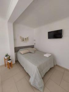 - une chambre blanche avec un lit et une télévision dans l'établissement Monoambiente en excelente ubicación, à Mendoza