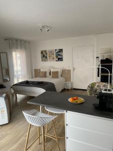 a bedroom with a bed and a kitchen with a table at Aix Homes "Les Allées Provençales" in Aix-en-Provence