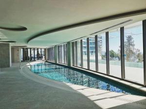 a large swimming pool in a building with windows at Del Mar Beachfront Boutique Residence in Limassol