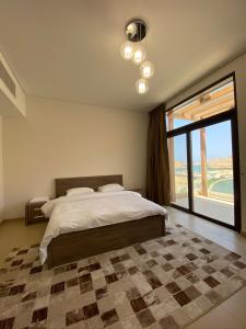 a bedroom with a large bed and a large window at W muscat bay in Muscat