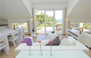 a living room with white furniture and a view of the ocean at Nice Home In Prigradica With Jacuzzi, Wifi And Outdoor Swimming Pool in Prigradica