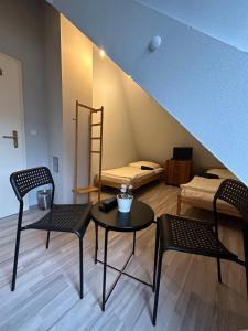Pokój z 2 krzesłami, stołem i łóżkiem w obiekcie Belle Vue w mieście Fürth