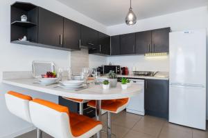 kuchnia ze stołem z pomarańczowymi krzesłami w kuchni w obiekcie 1-Br apartment in Palm Beach swimming pool parking w Cannes