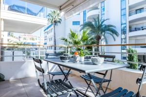 stół i krzesła na balkonie z palmami w obiekcie 1-Br apartment in Palm Beach swimming pool parking w Cannes