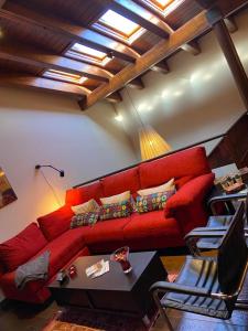 un soggiorno con divano rosso e tavolo di Ca l’Andreu Suites ad Alás