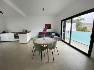 een keuken en eetkamer met een tafel en stoelen bij Casa Monte y Mar in Morro del Jable