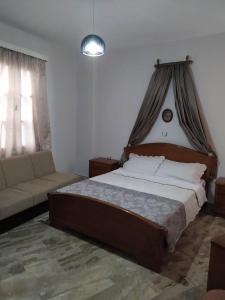 1 dormitorio con 1 cama grande y 1 sofá en Kisiris House, en Mandrákion