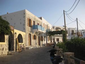 una calle con edificios blancos y un balcón azul en Kisiris House, en Mandrákion