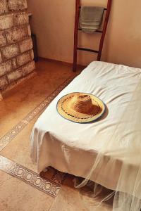 a white bed with a hat on top of it at Posada Gallinas in Palomino