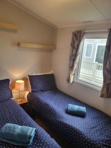 a bedroom with two beds and a window at Beach View in Whitstable