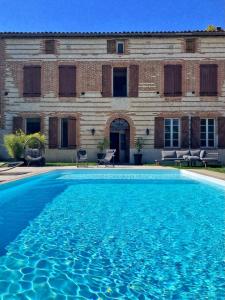 une grande piscine bleue en face d'un bâtiment dans l'établissement La roul'hôte dépote, à Monbéqui