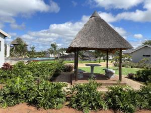 a pavilion with a table and a grass roof at Bluewave Farm Villa in Louis Trichardt