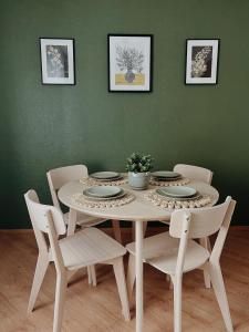 una mesa de comedor con sillas y una mesa con platos y flores en Rauna Apartment NR 8, en Rauna