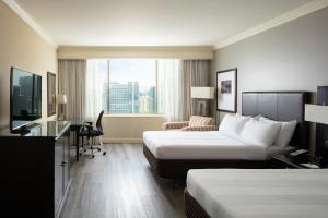 um quarto de hotel com duas camas e uma secretária em Santiago Marriott Hotel em Santiago