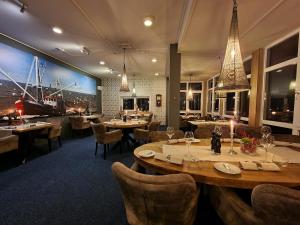 een restaurant met tafels en stoelen en een grote muurschildering bij Eemshotel in Delfzijl