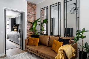 a living room with a brown couch and some plants at Fabia in Turku