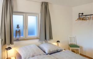 een slaapkamer met een bed voor een raam bij Nice Apartment In Loxstedt With Wifi And 1 Bedrooms in Loxstedt
