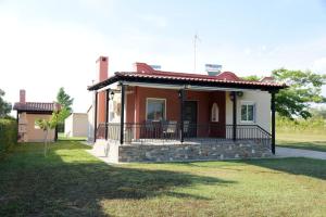 a small house with a porch and a balcony at Potamos Studios by GERANI in Órmos