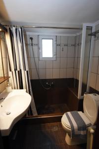 a bathroom with a sink and a shower and a toilet at Potamos Studios by GERANI in Órmos