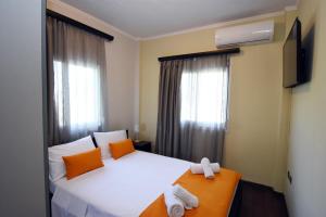 a bedroom with a bed with orange and white towels on it at Potamos Studios by GERANI in Órmos