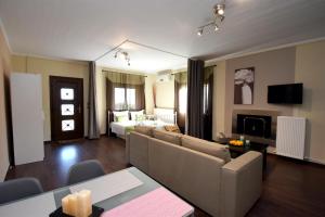 a living room with a couch and a bed at Potamos Studios by GERANI in Órmos