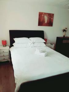 a large white bed with white sheets and pillows at Spacious and Tastefully Decorated Town House In Lakeside West Thurrock Grays in West Thurrock