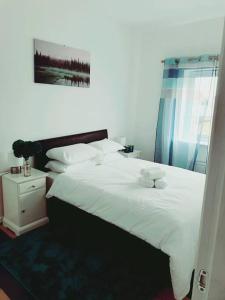 1 dormitorio con 1 cama grande con sábanas y almohadas blancas en Spacious and Tastefully Decorated Town House In Lakeside West Thurrock Grays, en West Thurrock